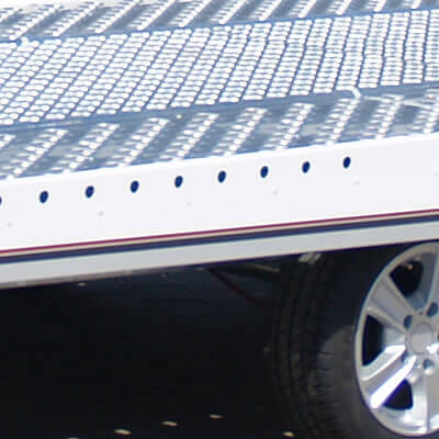 Otwory do mocowania aluminiowych stoperów transportowych rozmieszczone w burtach. Ułatwiają mocowanie pojazdu do transportu.